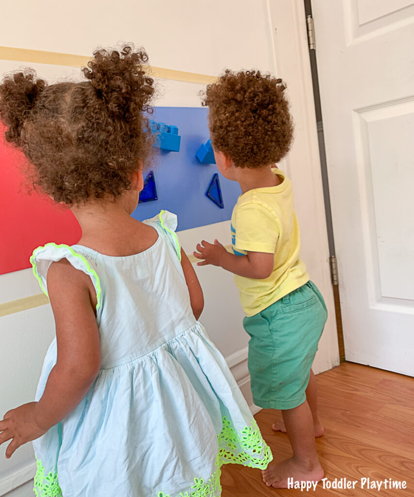 Twin toddlers Colour sorting red and  blue on a sticky wall