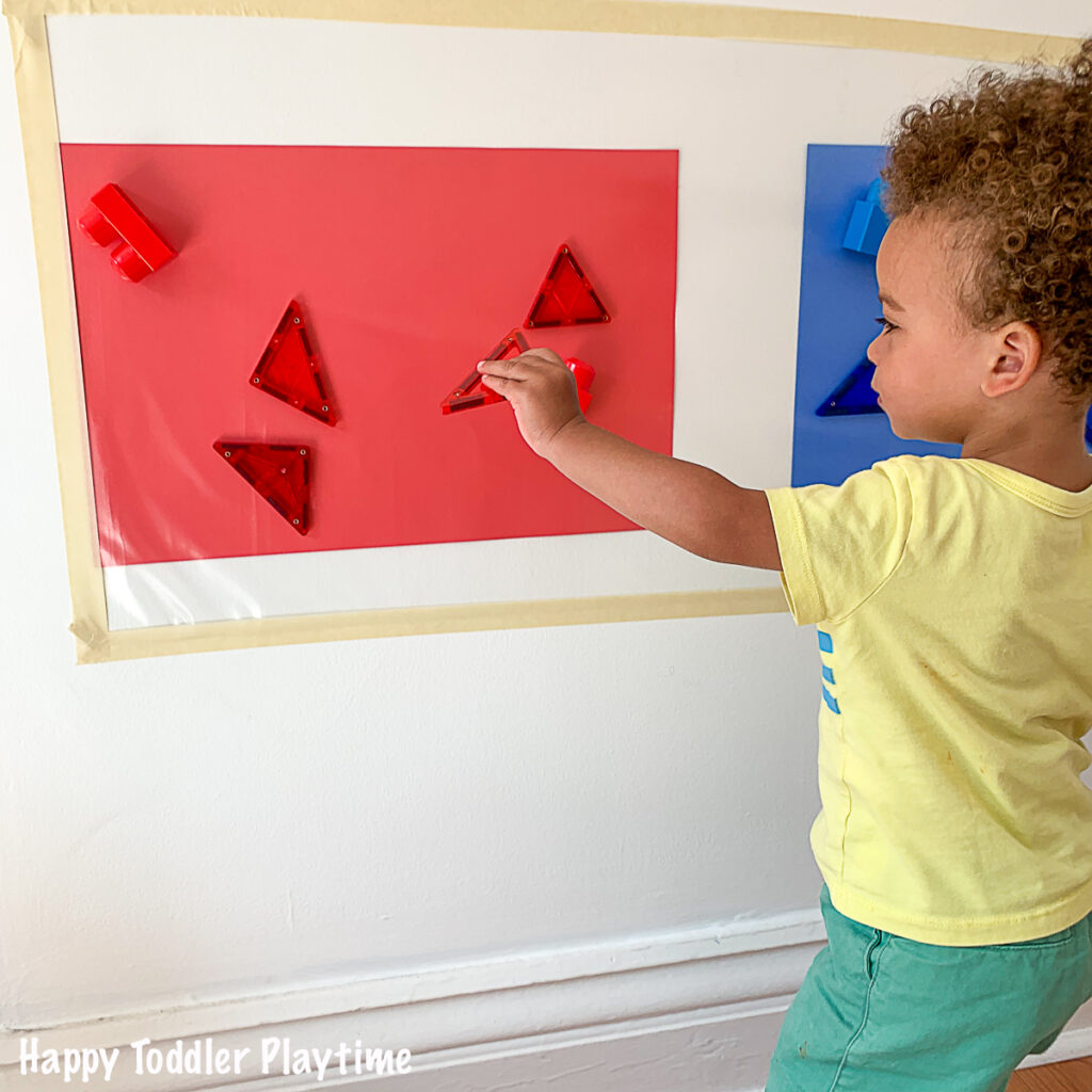 toddler Colour sorting red and  blue on a sticky wall